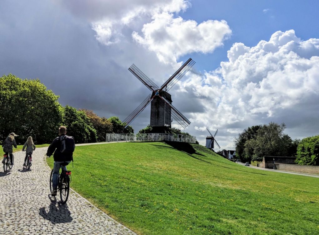 Een molen op de Kruisvest, met fietsers op het grasveld